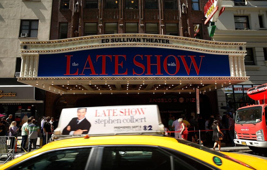 Exterior of the Ed Sullivan Theater in New York City, home of The Late Show with Stephen Colbert, with the illuminated marquee visible at night.