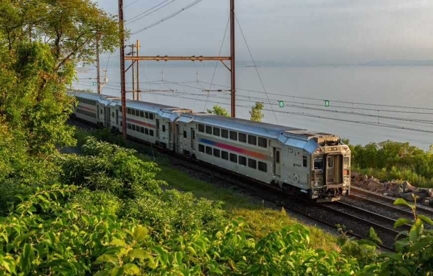 NJ Transit multilevel train running along the Hudson River waterway on the North Jersey Coast Line