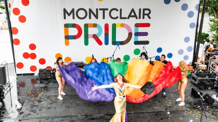 Performers wave a rainbow flag on stage during Montclair Pride Fest, the annual LGBTQ+ celebration organized by Out Montclair.