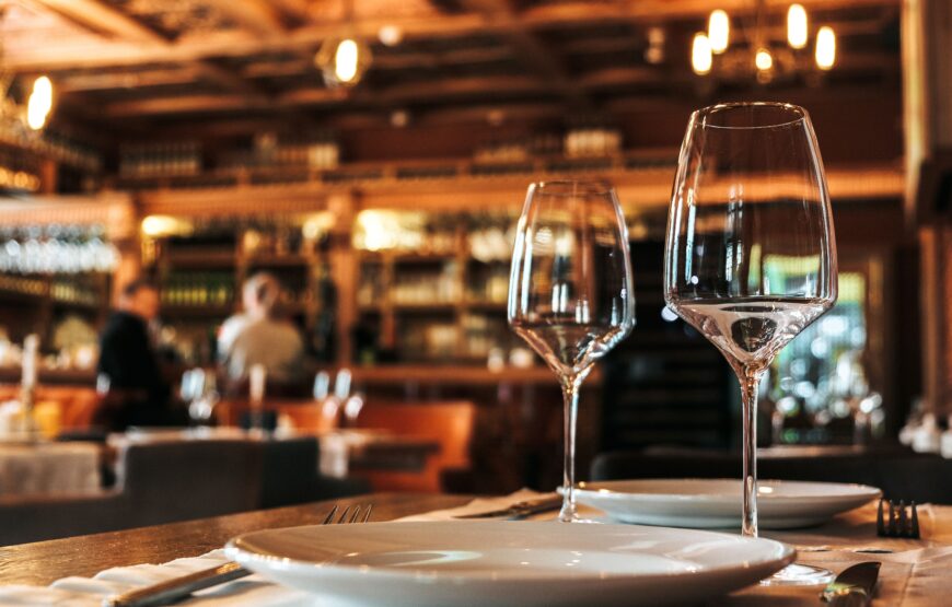 Wine glasses set on a restaurant table, illustrating how BYOB restaurants in Montclair offer wine through winery partnerships and retail delivery services.