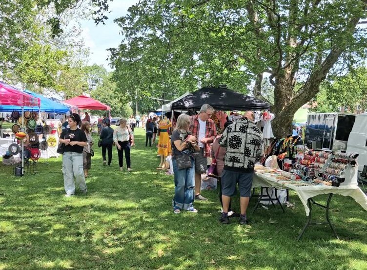 Shoppers browse vendor tables at an outdoor flea market in Clifton, NJ