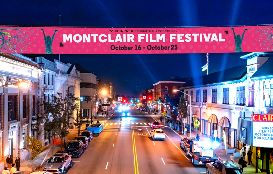 Montclair Film Festival 2026 banner hanging over Bloomfield Avenue near the Clairidge at night