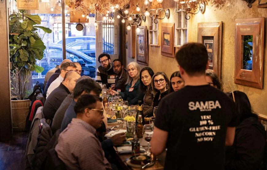 Chow Town food tour group gathered inside Samba Bar and Grill in Montclair, NJ, listening to a guide during a stop on the Montclair food tour