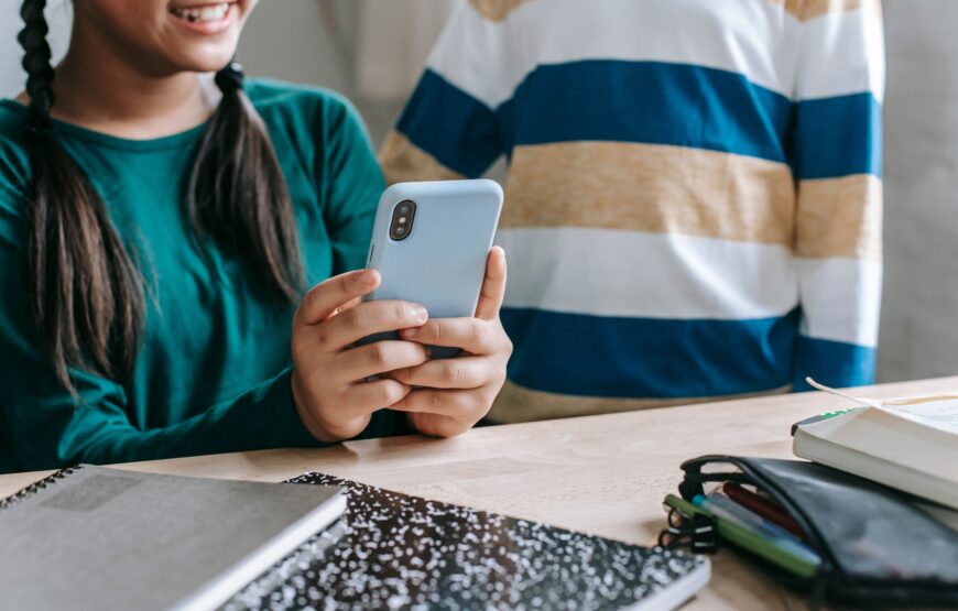Students using a smartphone at a school desk